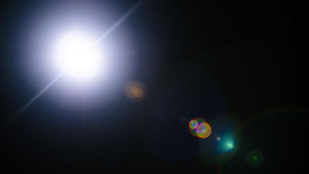 Abstract Natural Sun flare or Far star on the black background - image
