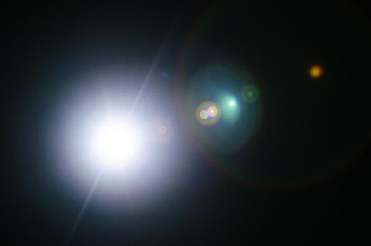 Abstract Natural Sun flare or Far star on the black background - image