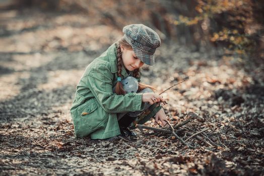 little girl making a bonfire, photo in vintage style