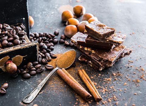 Chocolate, nuts, spices on a smooth black table