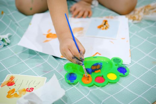 Children use watercolor brushes to create imagination and enhance their learning skills