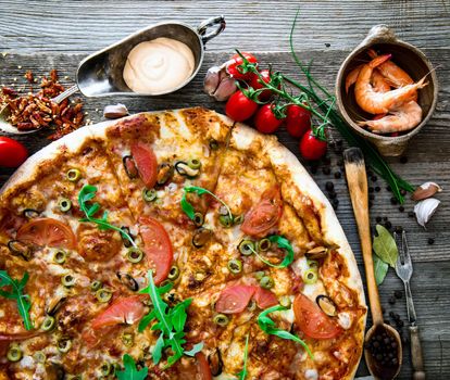 delicious pizza with seafood on wooden table