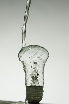 Light bulb made of water splashes. black and white dark photo