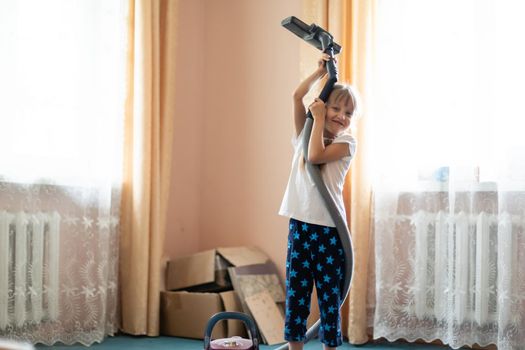 Little girl cleaning floor with vacuum cleaner