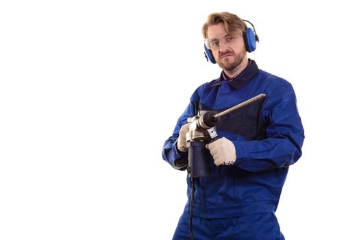 Construction worker in protective glasses and headphones with a puncher on a white background.