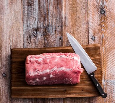 big piece of raw meat on cutting board