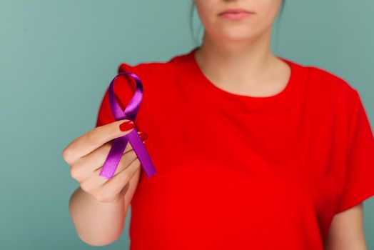 Elderly woman holding purple ribbon. Symbol is used to raise awareness for Alzheimer's disease, elder abuse, epilepsy, pancreatic cancer, thyroid cancer and lupus. Close up.