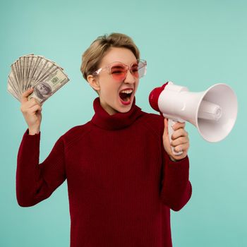 Young woman in pink sunglasses with money yelling to loudspeaker - image