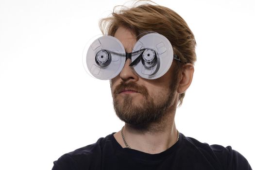 portrait of a man with glasses of tape reels of film on white background