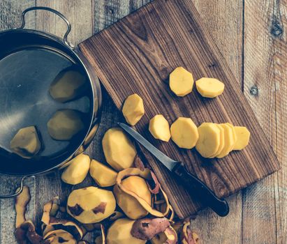 peeled and cut potato on wooden table