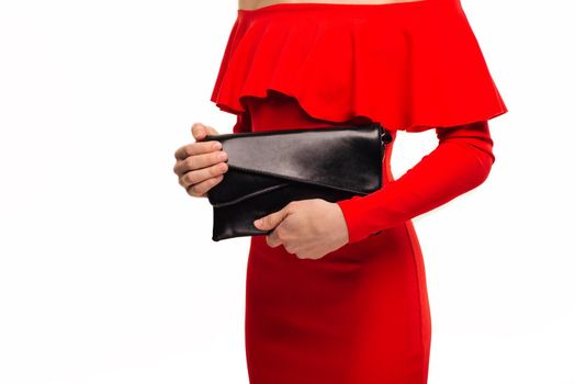 Fashionable woman with a black clutch in her hands and red evening dress on white background