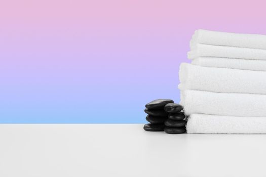 Spa still life with stacked towels and spa stone, front view