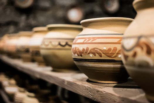 decorated clay pots on shop shelf