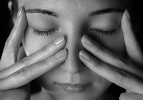 Woman is touching her nose and temporal region, woman is sick or tired