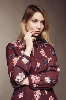 Portrait of a beautiful woman in a dress with floral pattern. Fashion photo