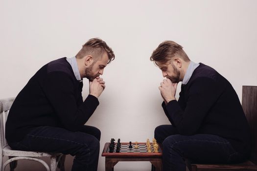 man playing chess against himself. thinks over the step