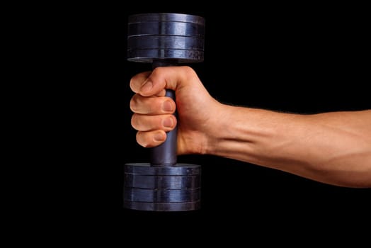 Male hand holds dumbbell on a black background