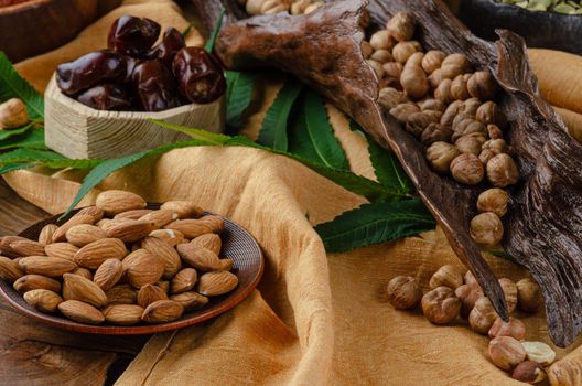 still life of nuts and dried fruits on a wooden table with fern leaves