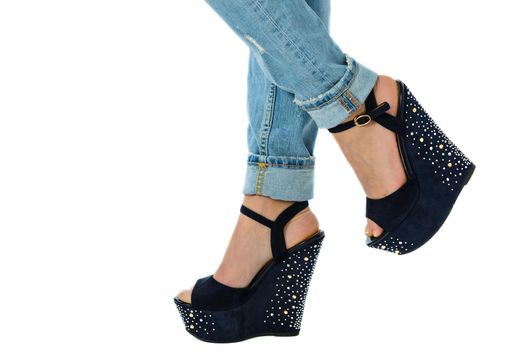 girl in jeans and high heels with studs and rhinestones on white background