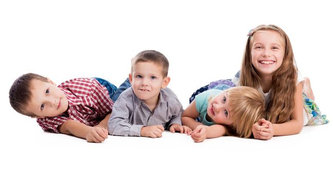 four cute children lying on the floor isolated on white background