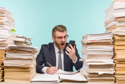Business executive swears on the phone for poorly done work working in the office and piles of paperwork, he is overloaded with work - image