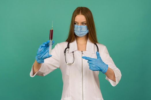 Covid19, coronavirus. Portrait of professional confident young caucasian doctor in medical mask and white coat, stethoscope over neck,with vaccine syringe in hand, fight disease - image