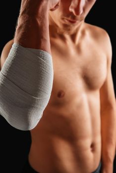 Man with bandaged elbow joint, tension