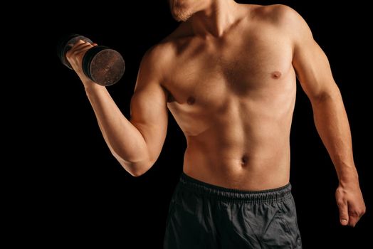 Unrecognizable muscular man makes exercises with dumbbell