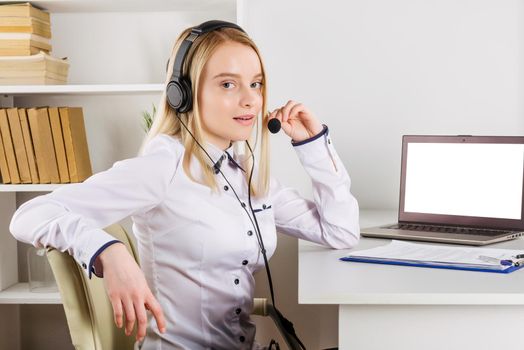 Portrait of happy smiling female customer support phone operator at workplace. - Image