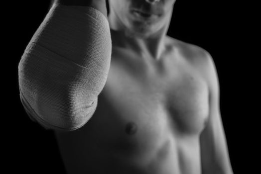 Bandaged male elbow joint, sprain, monochrome image