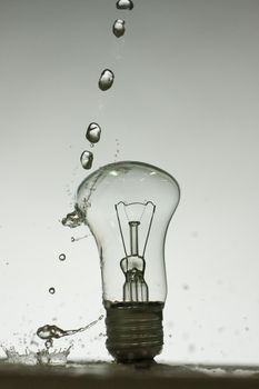 Light bulb made of water splashes. black and white dark photo