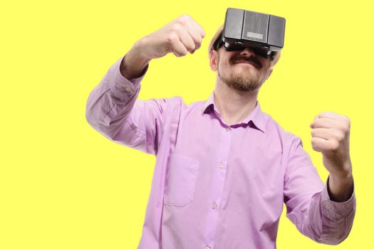 nice man with glasses of virtual reality in a lilac shirt on yellow background.