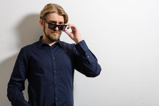 Portrait of a good looking young man with sunglasses indoors