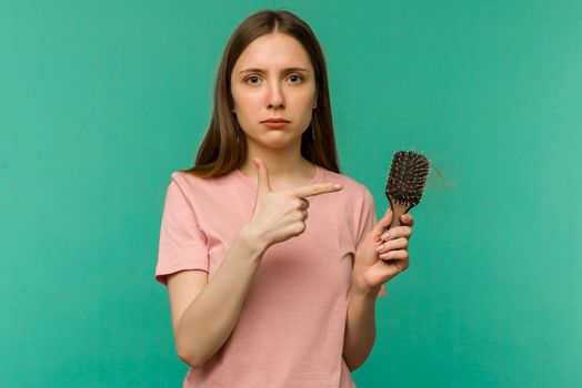 Young girl with a comb and problem hair on blue background - image