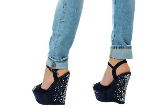 girl in jeans and high heels with studs and rhinestones on white background