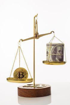 Bitcoin value increase trend. The coin outweighs the balance. On another bowl a stack of hundred dollar bills. White background - image