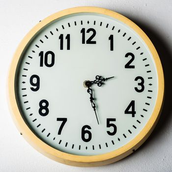 old round station clock on the white wall.