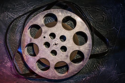 35 mm film reel with dramatic lighting on a dark background - image