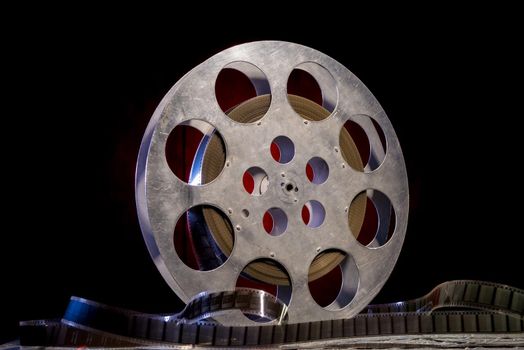 35 mm film reel with dramatic lighting on a dark background - image