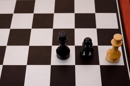 old chessboard and three figures on it.