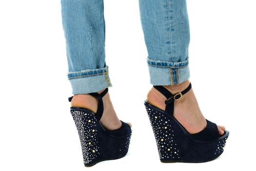girl in jeans and high heels with studs and rhinestones on white background