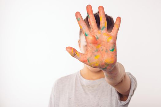 teenage girl covers her face with her right palm in paint