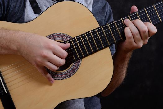 Acoustic guitar guitarist playing details. Musical instrument with performer hands.
