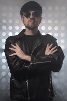 Portrait of young handsome brutal bearded biker in leather jacket and sunglasses.