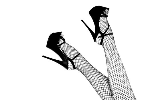 Sexy female legs in high heel red striptease shoes and fishnet stockings. - image