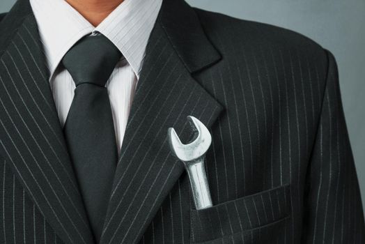 Wrench in a pocket of suit businessman, concept of business creation