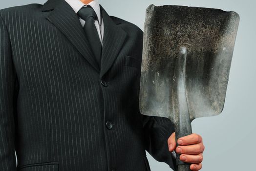 Unrecognizable businessman holds metal shovel, concept of business creation