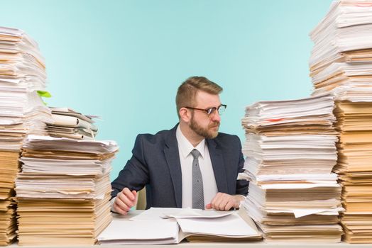 Business executive working in the office and piles of paperwork, he is overloaded with work - image