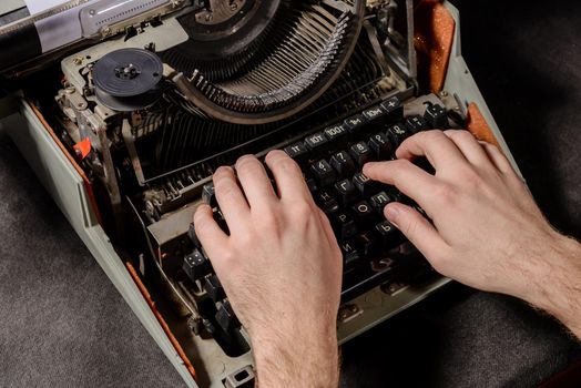 Hands writing on old typewriter