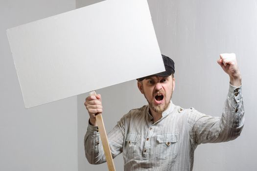 Angry protesting worker with blank protest sign.